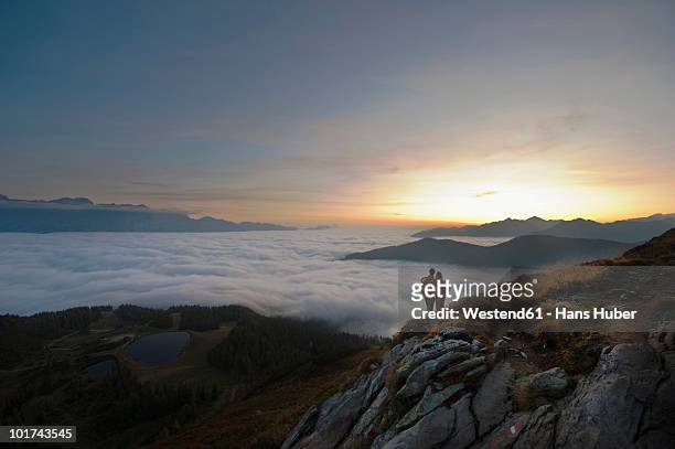austria, steiermark, reiteralm, hikers admiring view over clouds - coppia eterosessuale foto e immagini stock