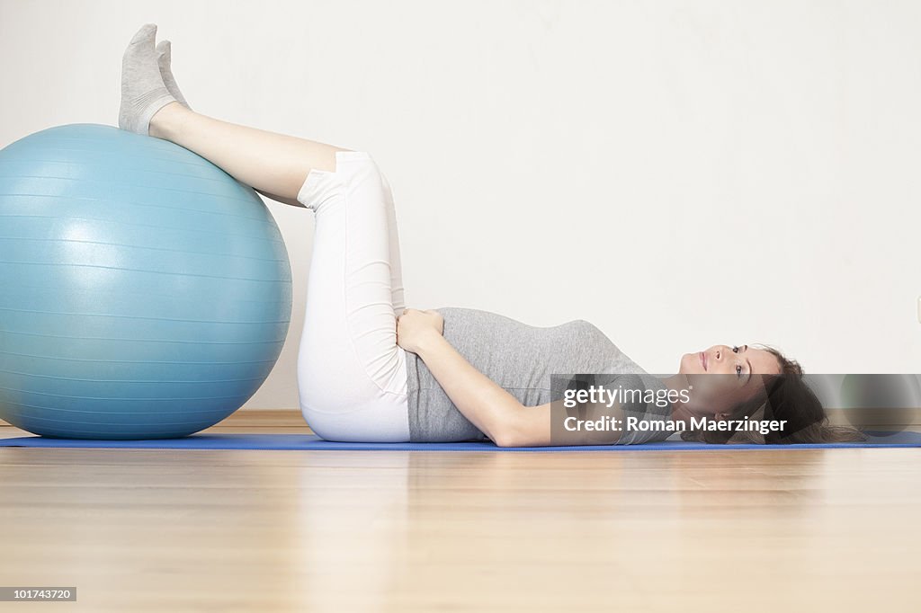 Pregnant woman lying on gymnastic mat