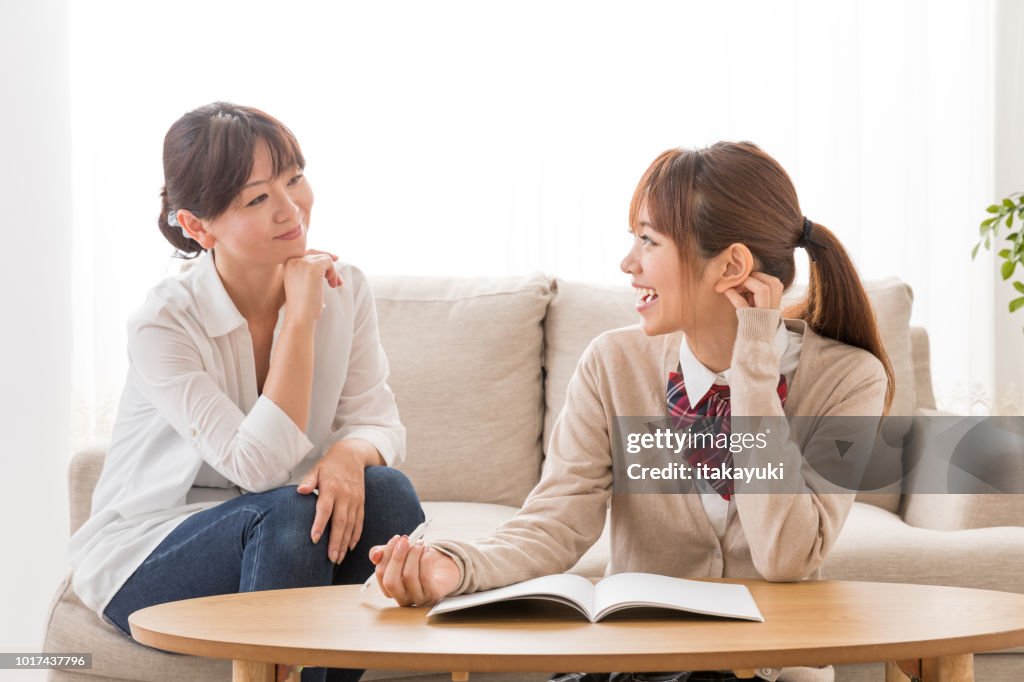 Asian mother and daughter relaxing in living room