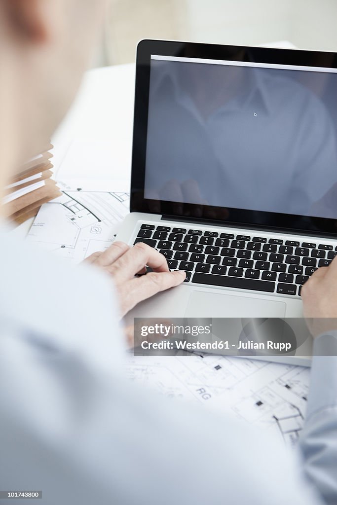 Businessman using laptop, rear view