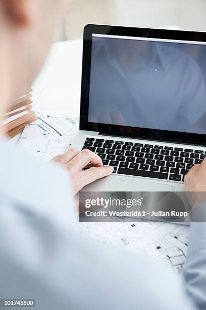 businessman using laptop, rear view - über die schulter stock-fotos und bilder