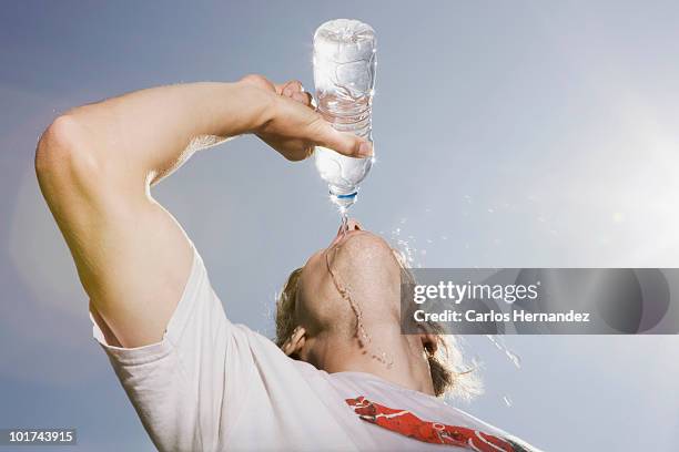 germany, berlin, young man drinking water from bottle, portrait - man drinking water stock pictures, royalty-free photos & images