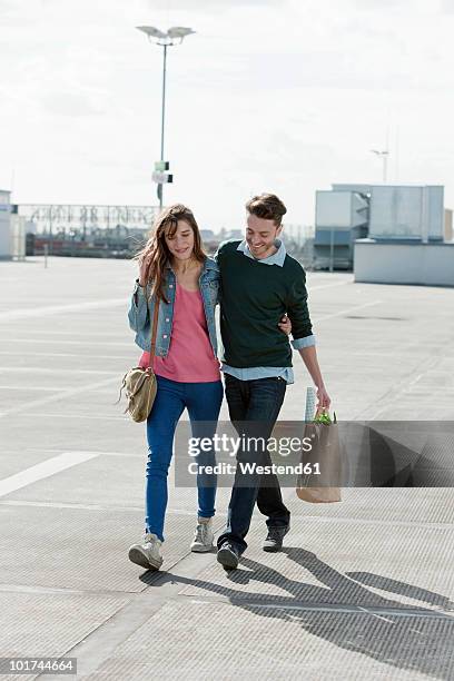 germany, berlin, young couple walking on deserted parking level - young couple shopping stock pictures, royalty-free photos & images