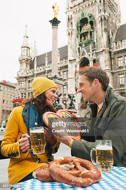 germany, bavaria, munich, marienplatz, couple, man holding gingerbread heart, portrait - munich marienplatz stock pictures, royalty-free photos & images