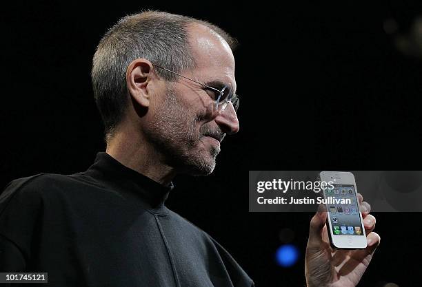 Apple CEO Steve Jobs holds the new iPhone 4 after he delivered the opening keynote address at the 2010 Apple World Wide Developers conference June 7,...