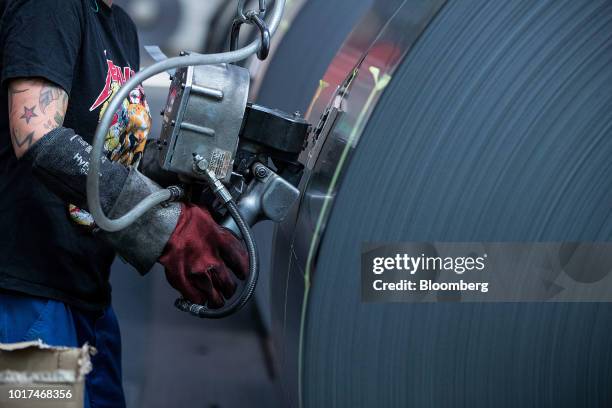 An employee binds a steel coil after temper rolling at the Thyssenkrupp Rasselstein GmbH steel packaging factory in Andernach, Germany, on Thursday,...