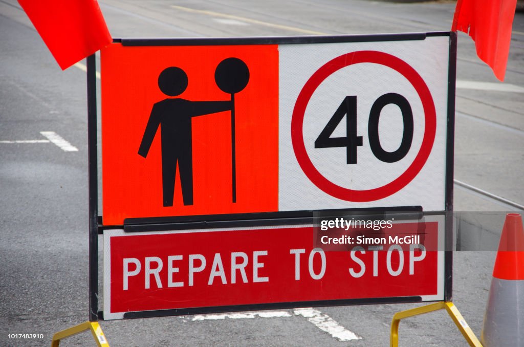 Signs warning drivers to prepare to stop, keep to a 40 kilomtre per hour speed limit and heed the worker with a stop sign