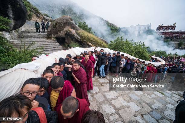 Monks from Drepung Monastery carry a massive Buddha thangka during the Sho Dun Festival on August 11, 2018 in Lhasa, Tibet Autonomous Region of...