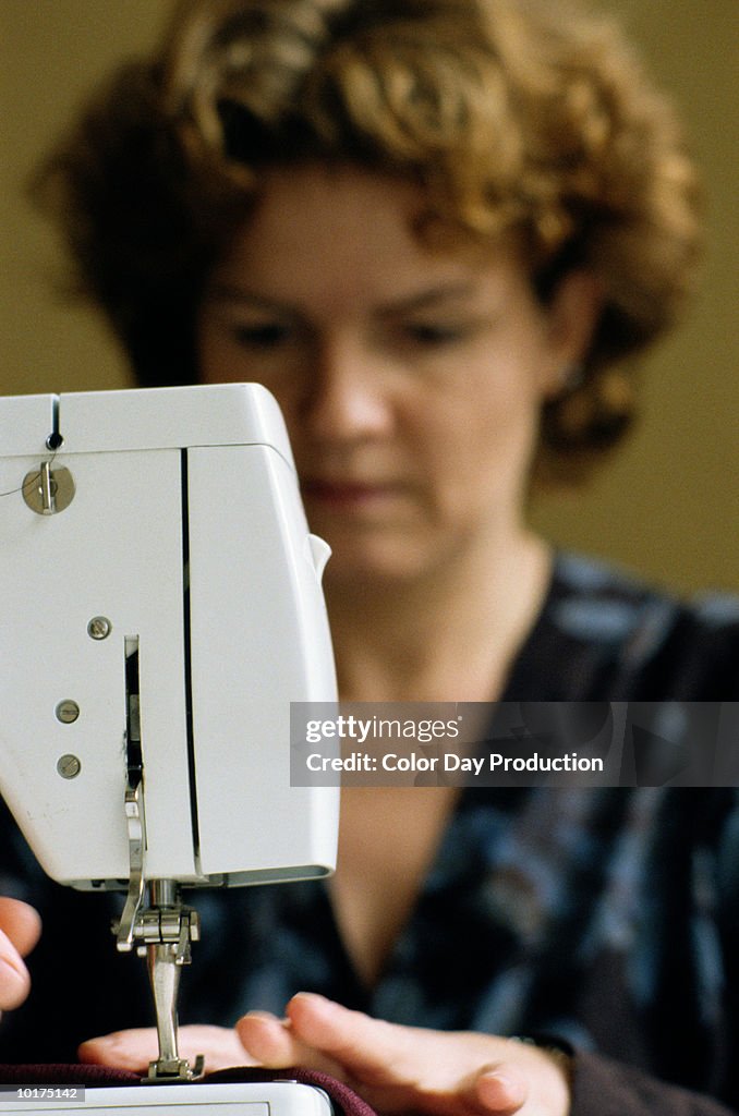 WOMAN USING SEWING MACHINE