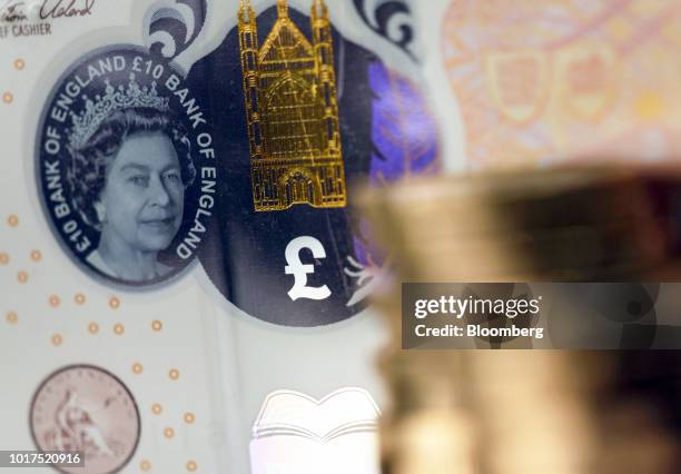 Transparent window featuring a portrait of Queen Elizabeth II sits next to a finely detailed metallic image of Winchester Cathedral and a colored...