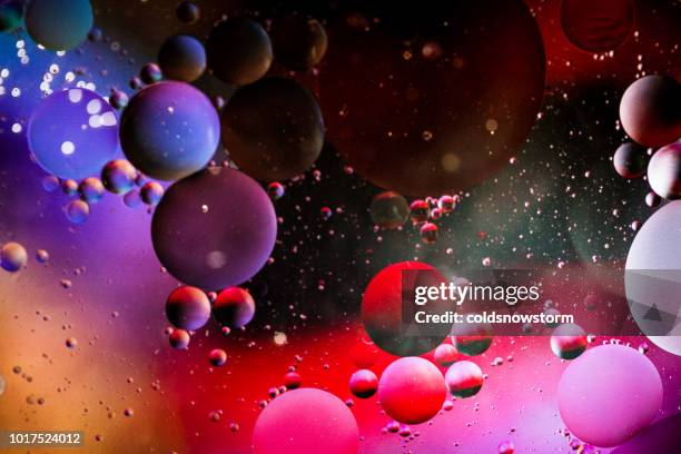 macro oil and water multi colored abstract background - liquid galaxy stock pictures, royalty-free photos & images