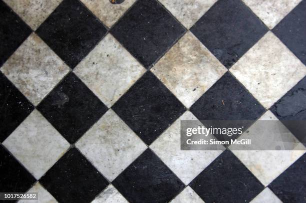 filthy black and white tiled doorstep - old tiled floor stock pictures, royalty-free photos & images