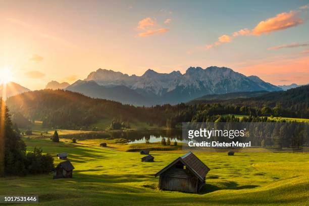 magic sunrise at alpine lake geroldsee - view to mount karwendel, garmisch partenkirchen, alps - hut stock pictures, royalty-free photos & images