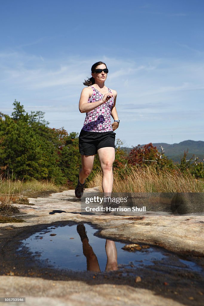 Woman running on a rocky trail in North Carolina.