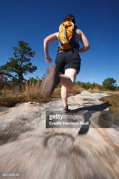 blur motion of woman running on a rocky trail in north carolina. - foresta statale dupont foto e immagini stock