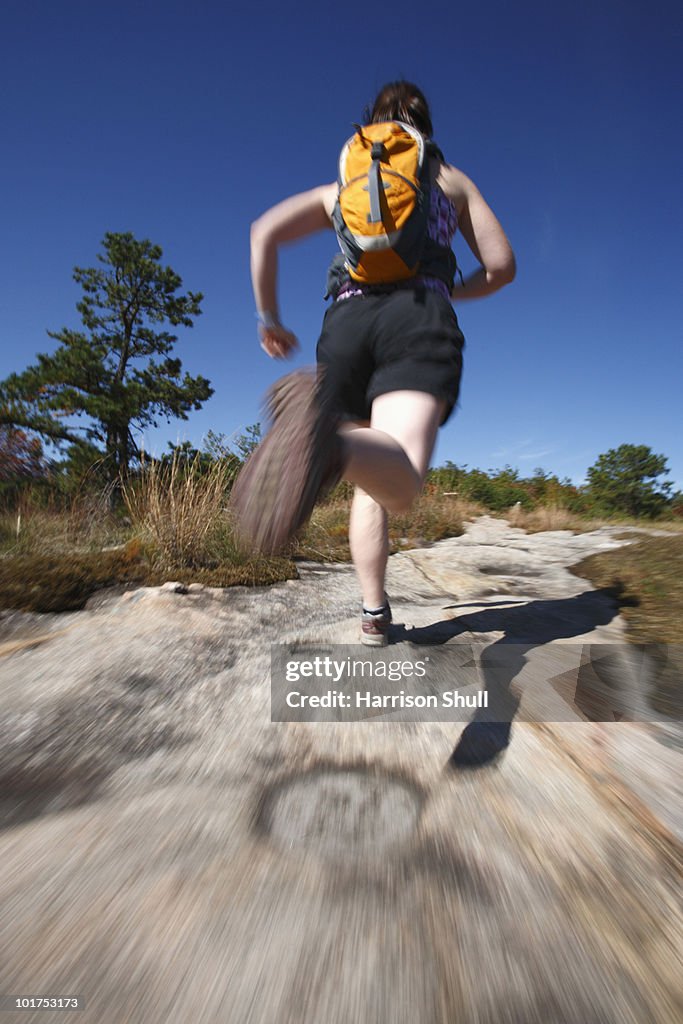 Blur motion of woman running on a rocky trail in North Carolina.