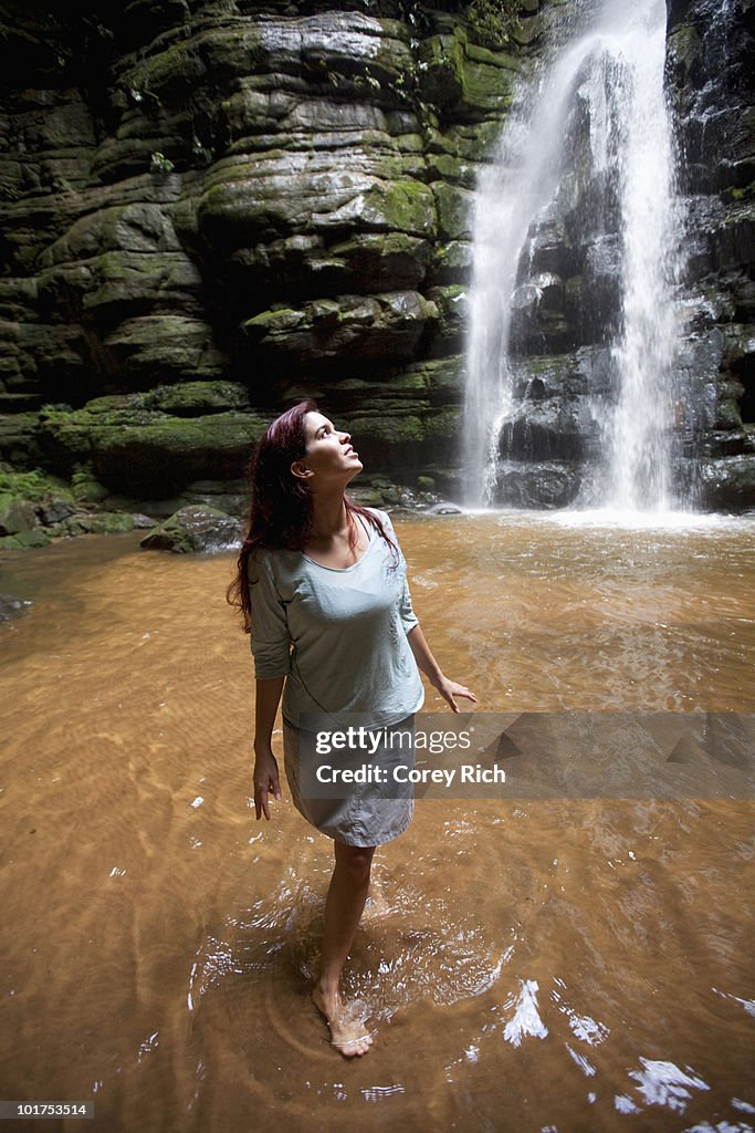 A woman observes a waterfall in Brazil.