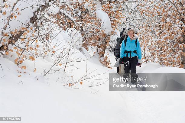 a young woman backpacking through snow in diamond fork, springville, utah. - springville utah stock pictures, royalty-free photos & images