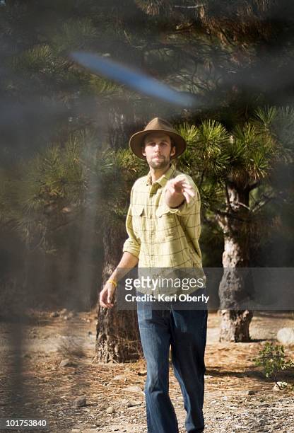 a young man shoots for par during a game of disc golf in lake tahoe, california. - disc golf stock-fotos und bilder