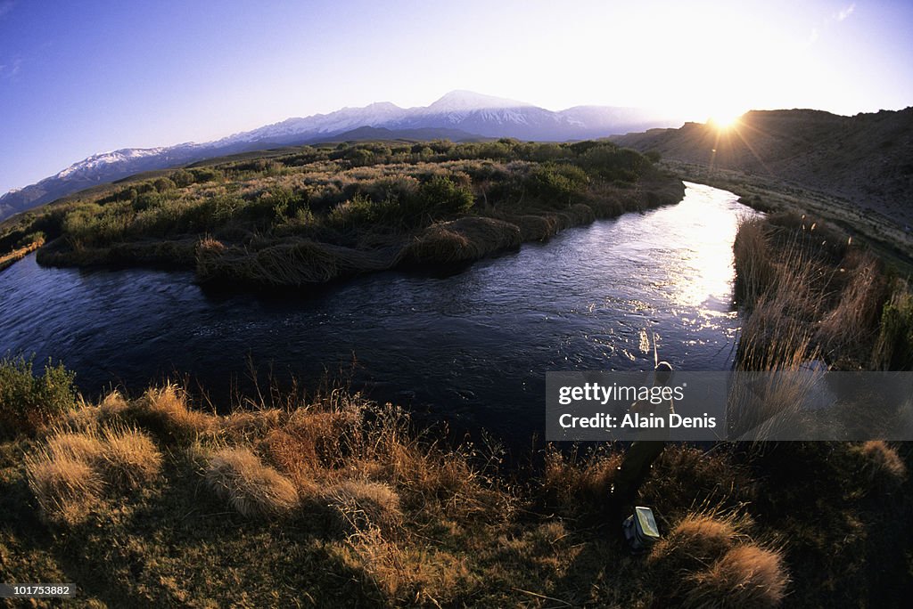 A man fly fishing at sunset in Bishop, California.