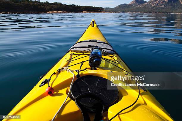 a sea kayak on a calm morning heads into coles bay, freycinet national park, tasmania, australia. - sea kayaking imagens e fotografias de stock