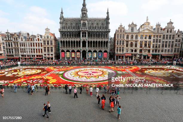 Picture taken on August 16, 2018 shows the installation of the annual Flower Carpet on the Grand Place - Grote Markt Square in the city center of...