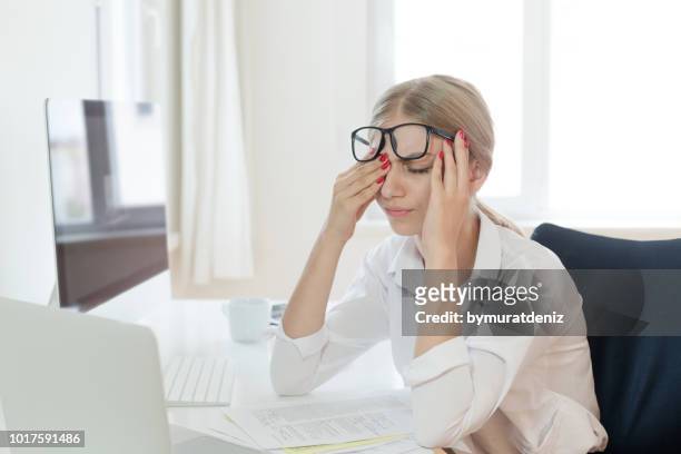 tired businesswoman rubbing eyes in office - rubbing stock pictures, royalty-free photos & images