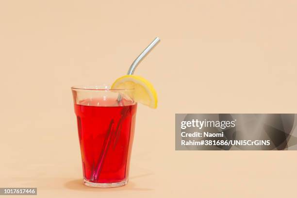 drink with reusable stainless steel straw in red drink - rietje stockfoto's en -beelden