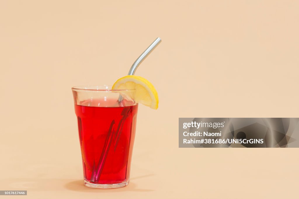 Drink with reusable stainless steel straw in red drink