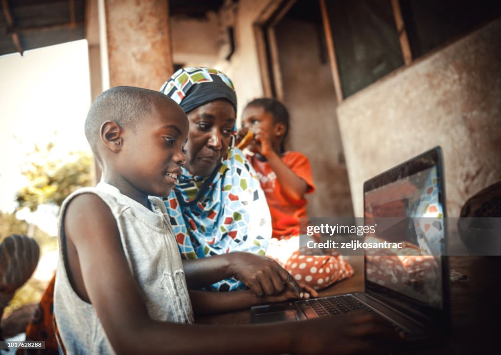 Happy african family together using laptop