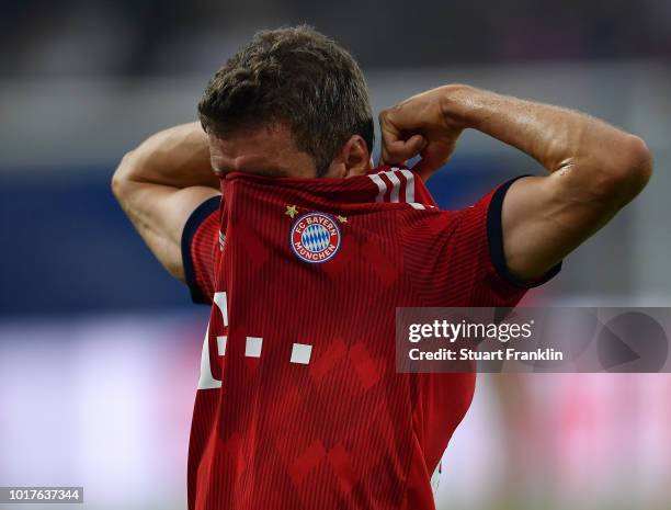 Thomas Mueller of Muenchen pulls off his shirt during the friendly match between Hamburger SV and Bayern Muenchen at Volksparkstadion on August 15,...