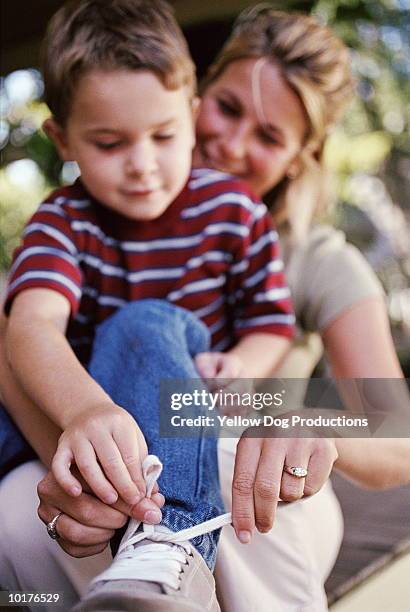 mom teaching son how to tie his shoelaces - boy tying shoes stock-fotos und bilder