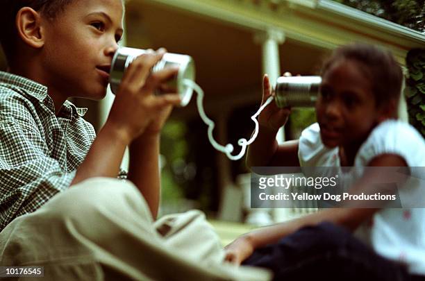 boy talking into tin-can phone, w/sister - tin can phone stock pictures, royalty-free photos & images