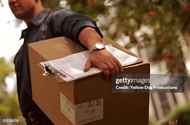 deliveryman carrying box - repartidor fotografías e imágenes de stock