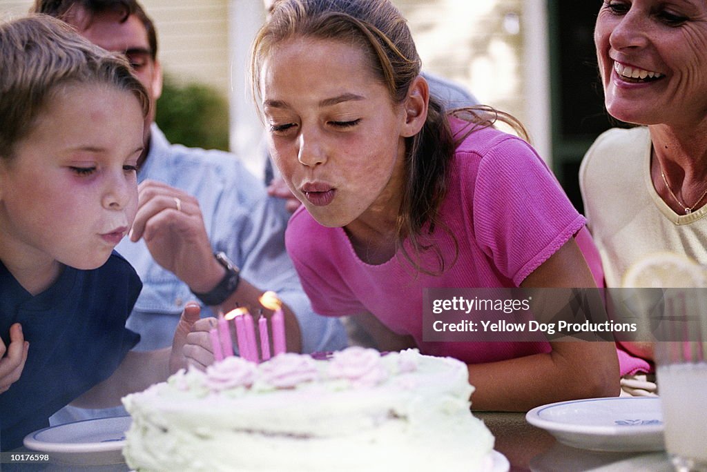 2 KIDS BLOWING OUT CANDLES ON CAKE