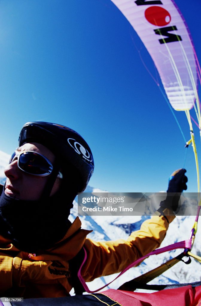 PARAGLIDING PILOT IN FLIGHT