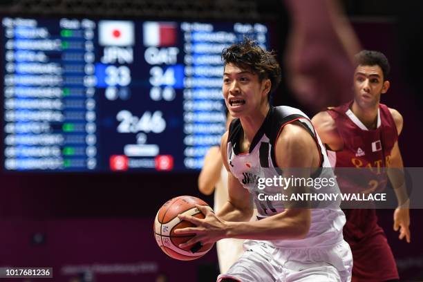 Japan's Takuma Sato runs with the ball in their men's basketball preliminary Group C game between Japan and Qatar during the 2018 Asian Games in...