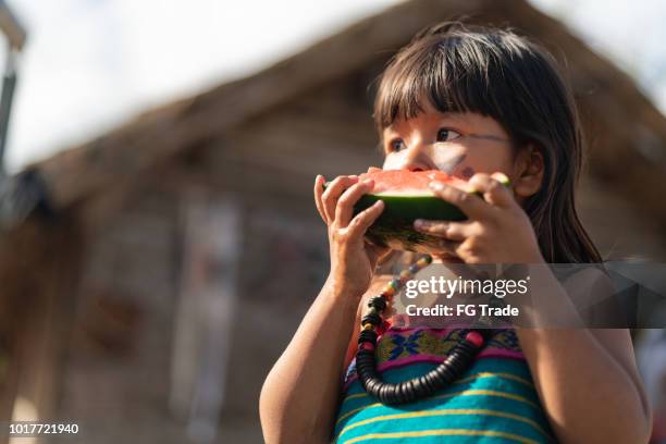 niño comiendo sandía - cultura indigena fotografías e imágenes de stock
