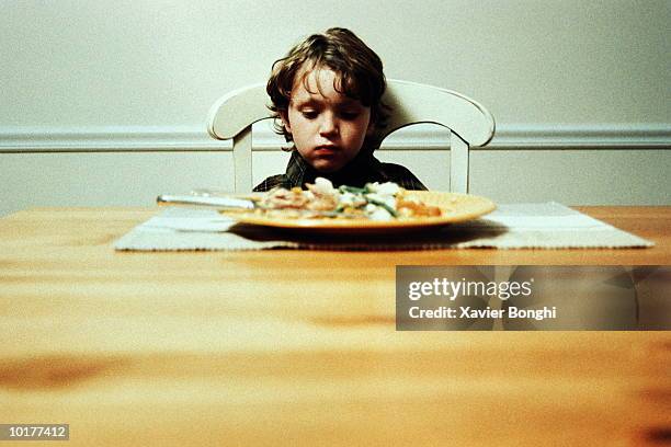 boy alone at dinner table, not eating - boy sad stock pictures, royalty-free photos & images