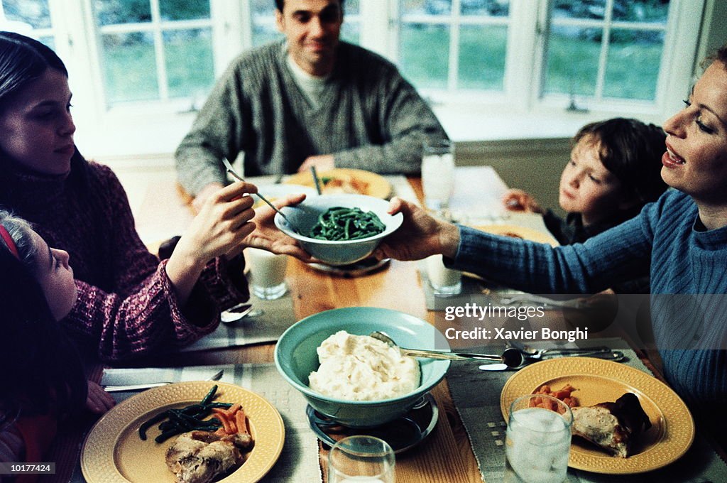 MOM PASSING GREEN BEANS AT DINNER TABLE