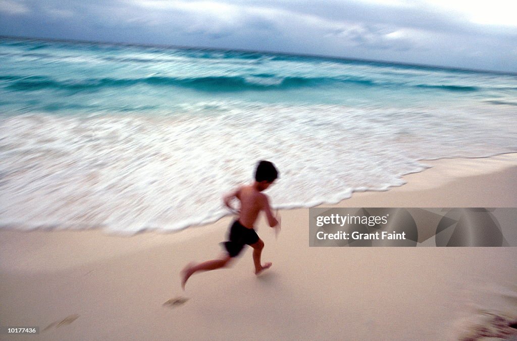 BOY RUNNING ON BEACH CANCUN, MEXICO