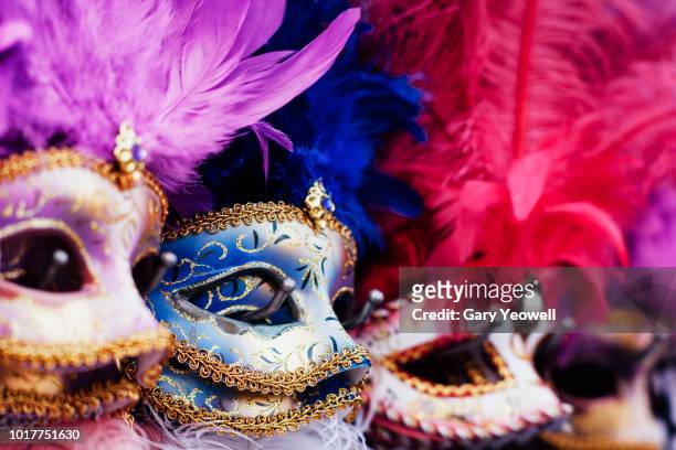 row of masks on display in venice - carnaval fotografías e imágenes de stock