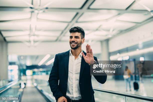 reisende, die am flughafen - waving hands goodbye stock-fotos und bilder