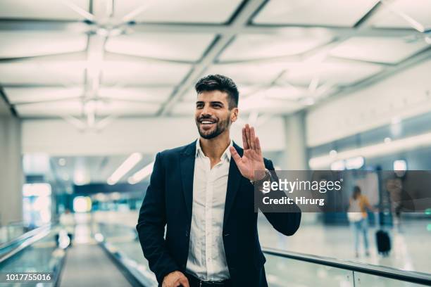 viaggiatore in aeroporto - sventolare la mano foto e immagini stock