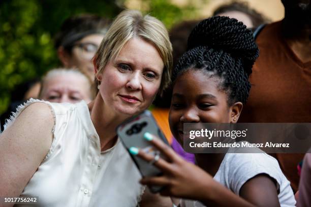 Democratic gubernatorial candidate Cynthia Nixon poses for a selfie with a girl as she attends a rally for universal rent control on August 16, 2018...