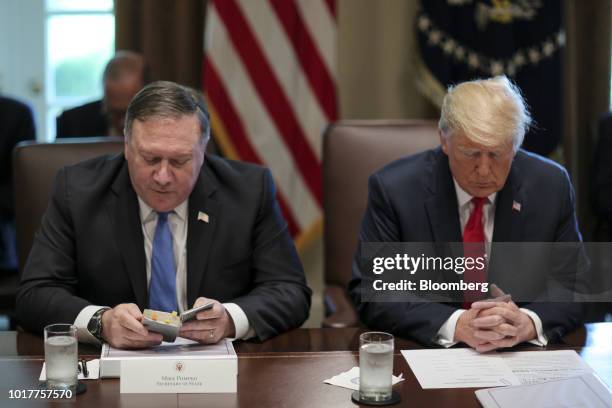 Mike Pompeo, U.S. Secretary of state, left, reads a prayer next to U.S. President Donald Trump during a meeting in the Cabinet Room of the White...