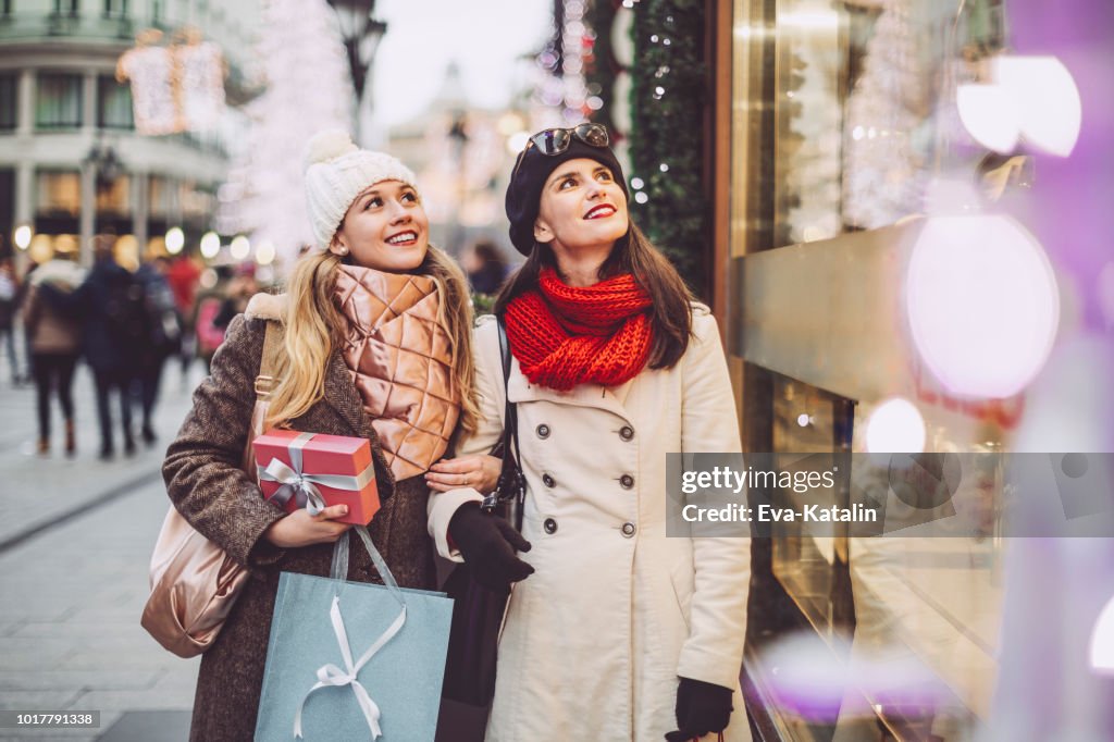 Las mujeres jóvenes son compras juntos para Navidad