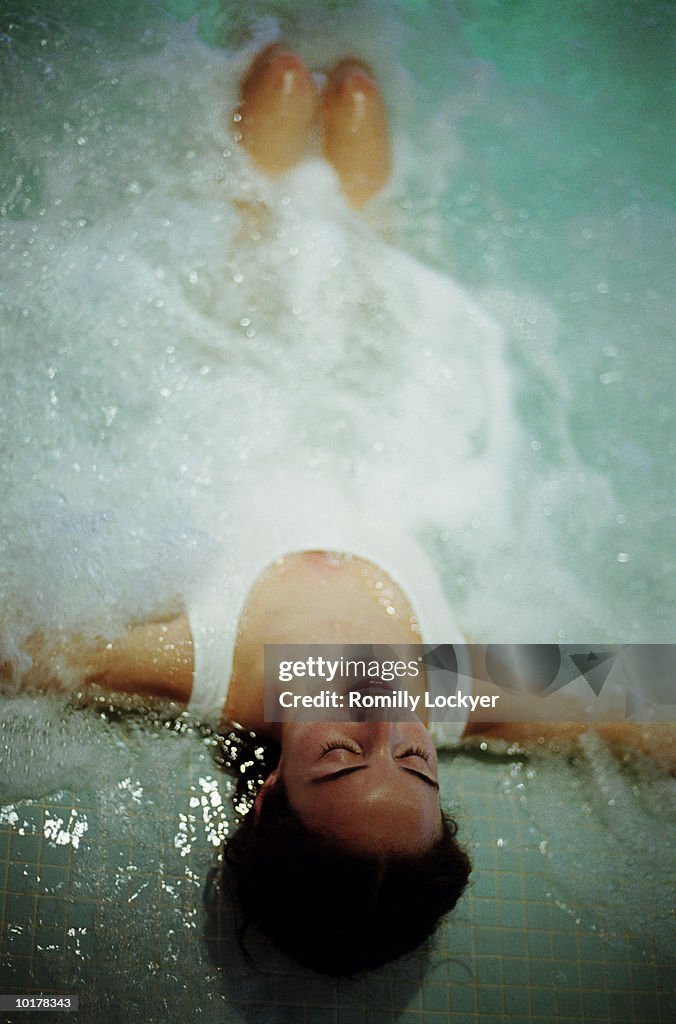 WOMAN RELAXING IN HOT TUB/SPA