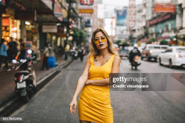 asiatische frau in der stadt - yellow dress stock-fotos und bilder