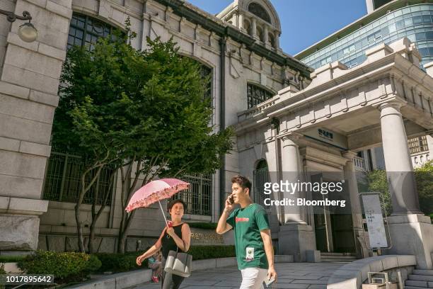 Pedestrians walk past the entrance to the Bank of Korea museum at the central bank's headquarters in Seoul, South Korea, on Thursday, Aug. 16, 2018....